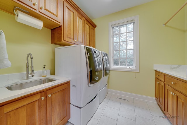 laundry area with cabinets, light tile patterned floors, plenty of natural light, and sink