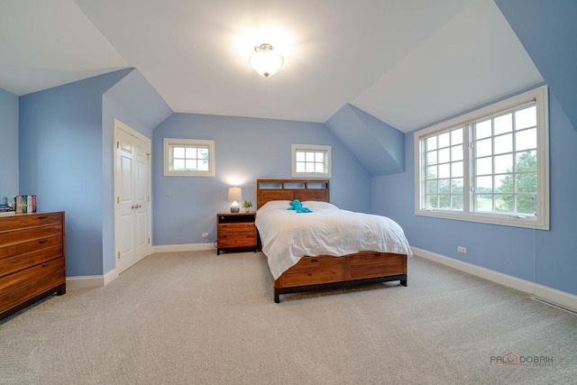 bedroom featuring light colored carpet and vaulted ceiling