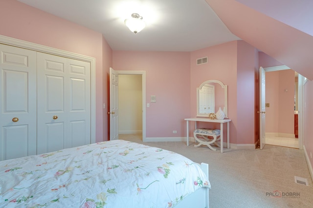 bedroom with light carpet and a closet