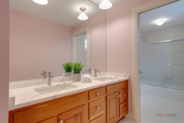 bathroom with tile patterned floors, vanity, and combined bath / shower with glass door