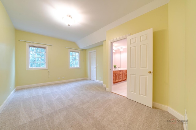 carpeted empty room with vaulted ceiling