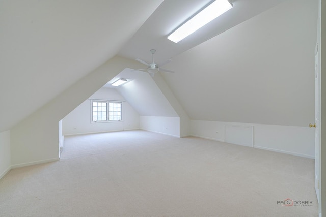 additional living space featuring ceiling fan, lofted ceiling, and light carpet