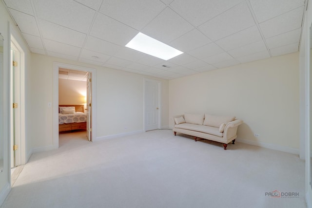 sitting room featuring a paneled ceiling and light colored carpet