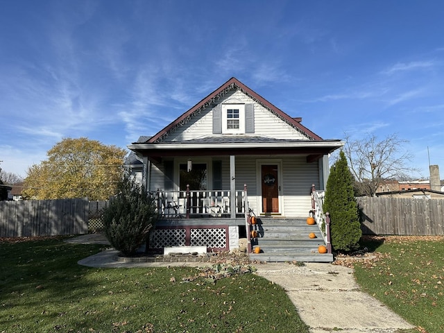 bungalow-style home with covered porch and a front yard