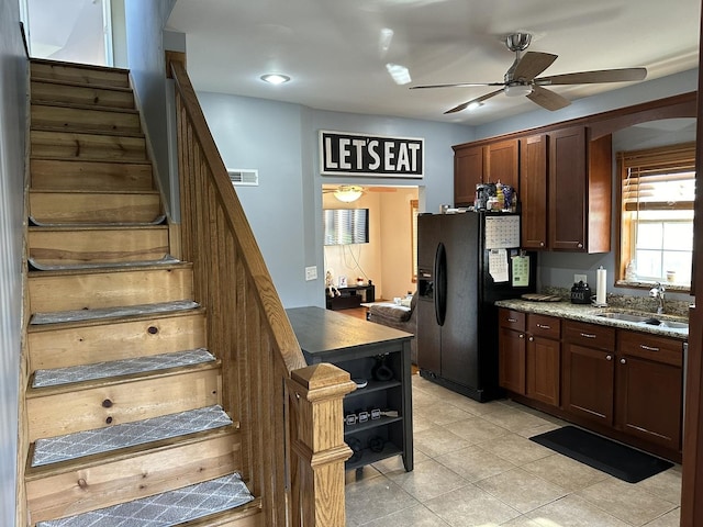 kitchen featuring black refrigerator with ice dispenser, sink, ceiling fan, and light tile patterned floors