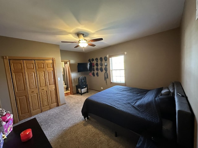 bedroom with ceiling fan, a closet, and light colored carpet