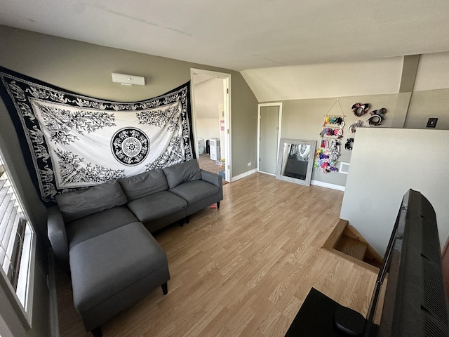 living room featuring light wood-type flooring and vaulted ceiling