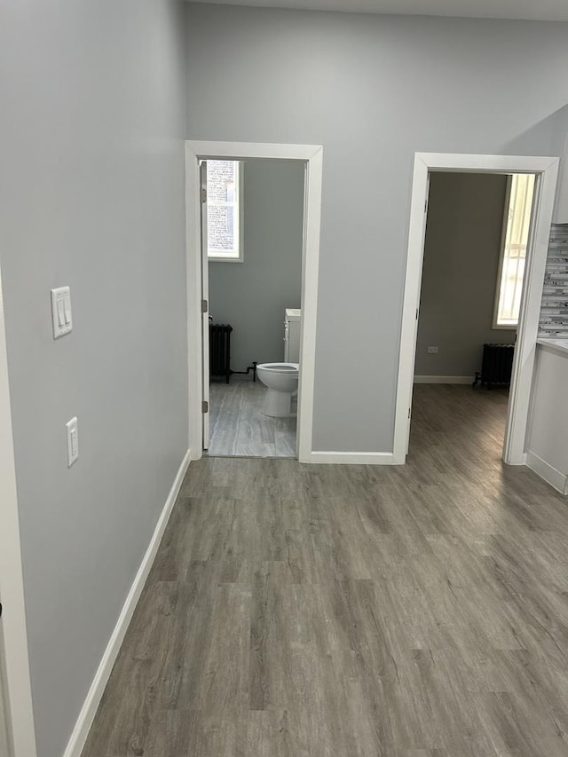 hall featuring light wood-type flooring and radiator