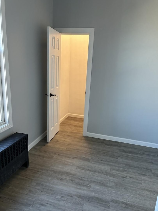 empty room with wood-type flooring and radiator