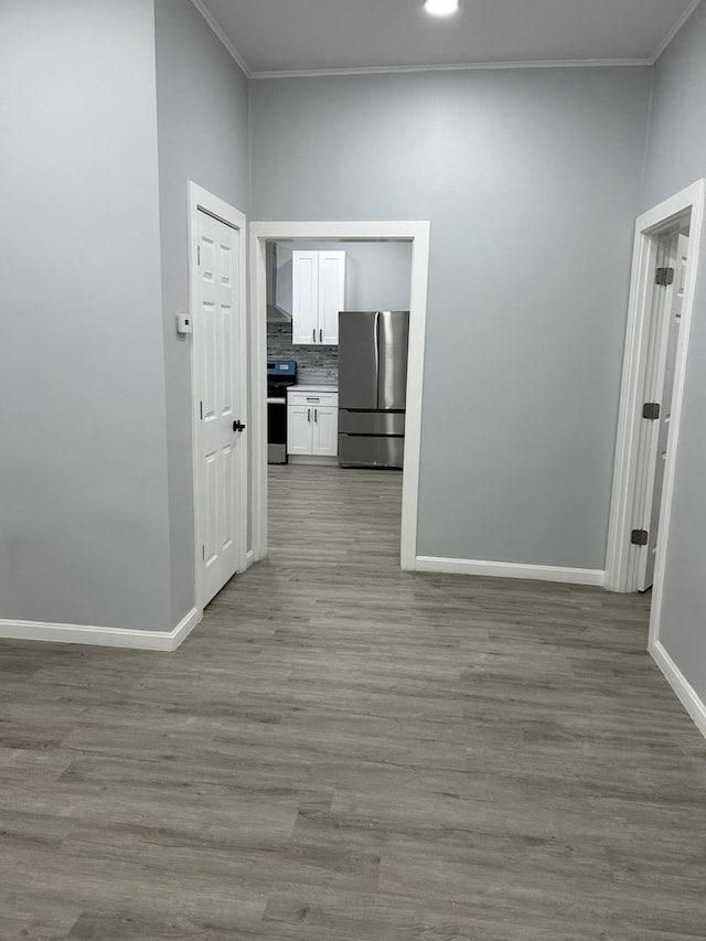 corridor featuring light wood-type flooring and crown molding