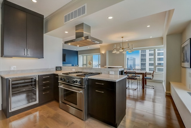 kitchen with kitchen peninsula, high end range, beverage cooler, and ventilation hood