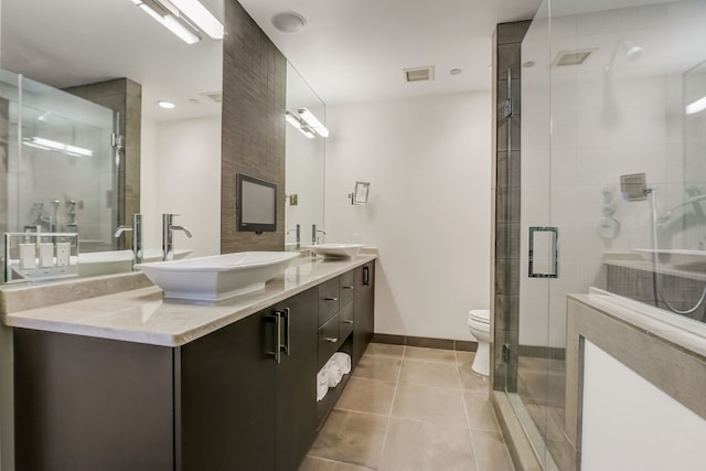 bathroom featuring tile patterned floors, a shower with door, vanity, and toilet