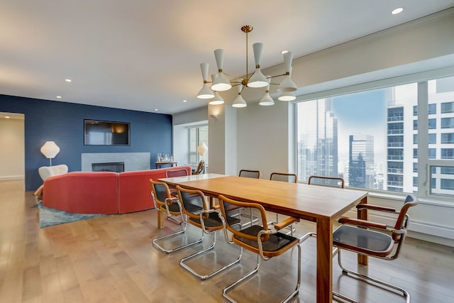 dining area with a healthy amount of sunlight, light hardwood / wood-style flooring, and a brick fireplace