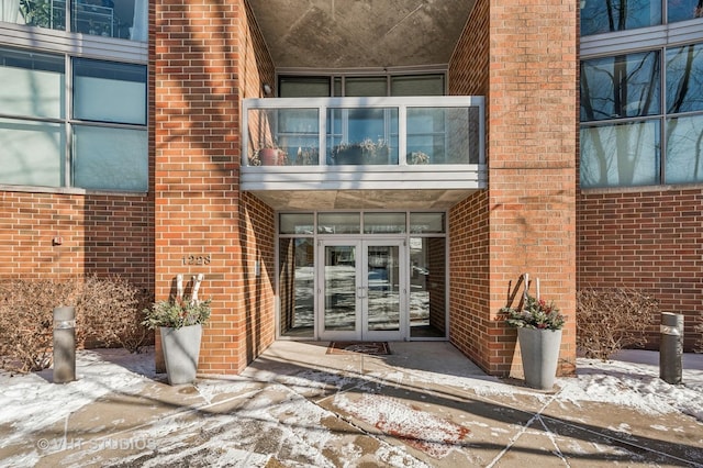 snow covered property entrance with french doors