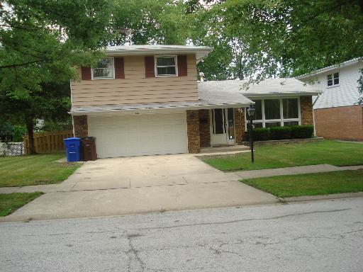 tri-level home with a garage, concrete driveway, a front yard, and fence