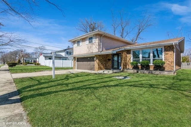 split level home featuring brick siding, concrete driveway, a front yard, fence, and a garage