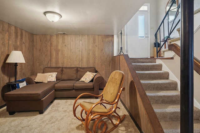 carpeted living room featuring wooden walls