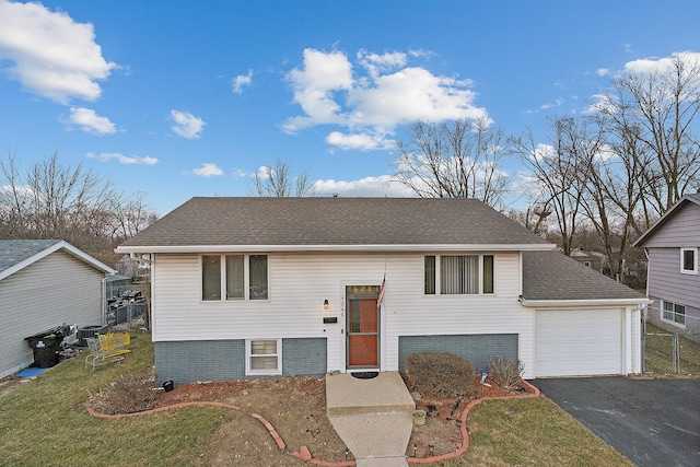 bi-level home with a garage and a front lawn