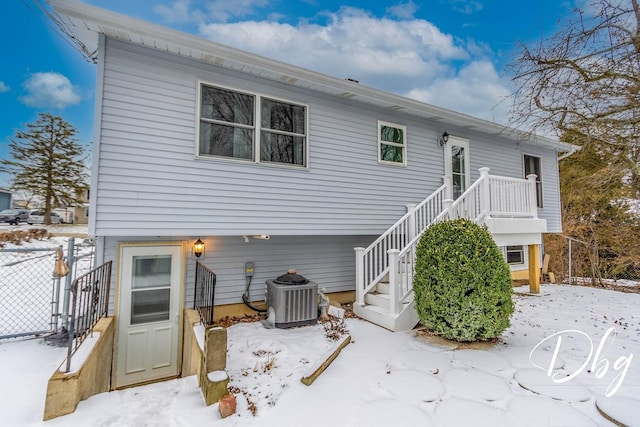 snow covered property featuring central AC