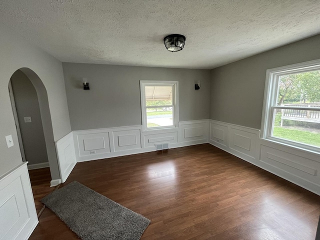 spare room with dark hardwood / wood-style floors and a textured ceiling