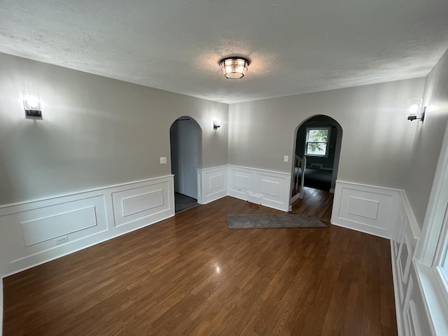 spare room featuring dark hardwood / wood-style floors and a textured ceiling