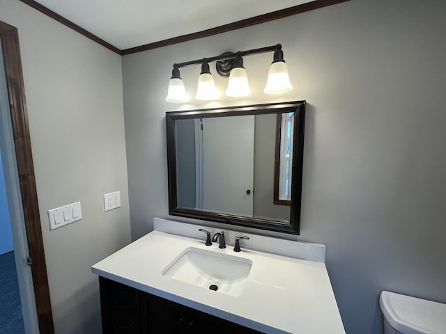 bathroom with vanity, crown molding, and toilet