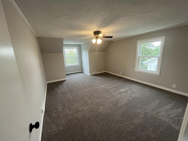 bonus room with lofted ceiling, ceiling fan, dark carpet, and a textured ceiling