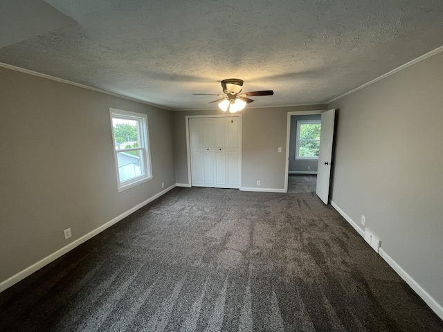 carpeted empty room with ceiling fan, ornamental molding, and a textured ceiling