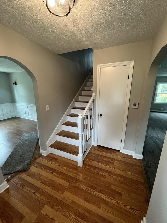 stairway featuring hardwood / wood-style flooring and a textured ceiling