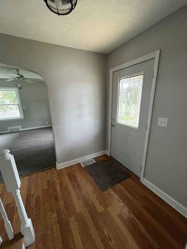 entryway with plenty of natural light, dark hardwood / wood-style flooring, and a textured ceiling