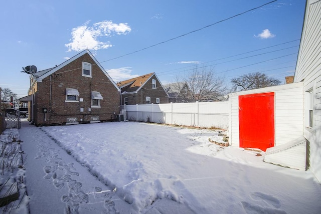 snow covered back of property featuring central air condition unit