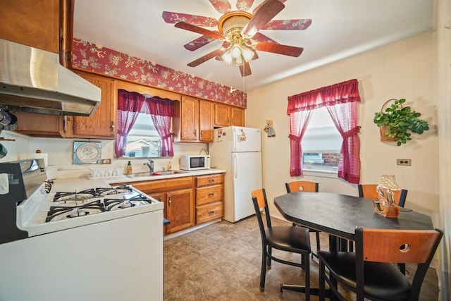 kitchen with white appliances, ceiling fan, and sink