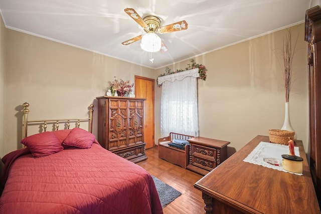 bedroom featuring ceiling fan, ornamental molding, and light parquet flooring