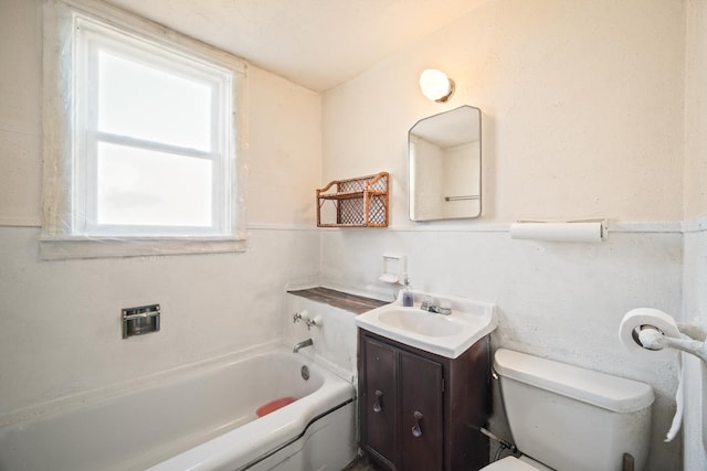 bathroom with toilet, vanity, and a washtub