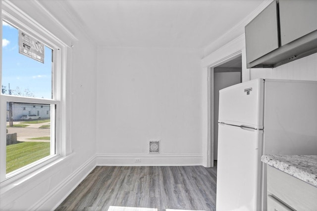 kitchen featuring gray cabinetry, white fridge, and wood-type flooring