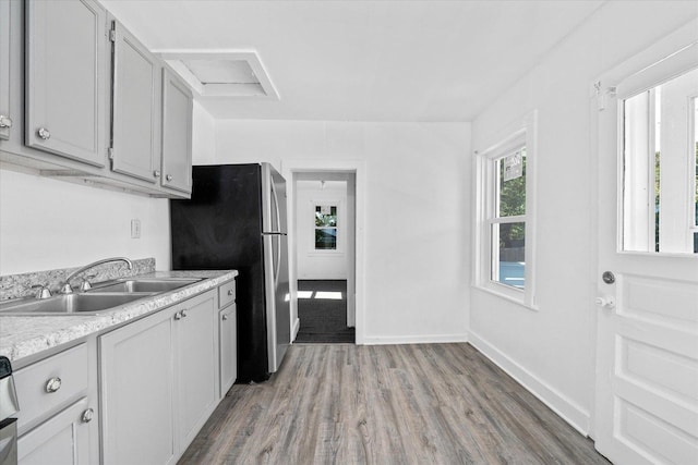 kitchen featuring sink, stainless steel refrigerator, and light hardwood / wood-style flooring