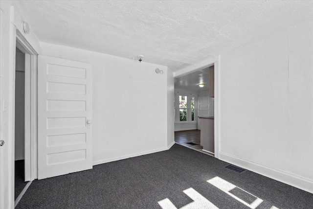 carpeted spare room featuring a textured ceiling