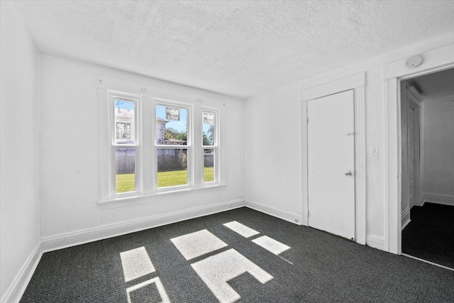 carpeted empty room with a textured ceiling