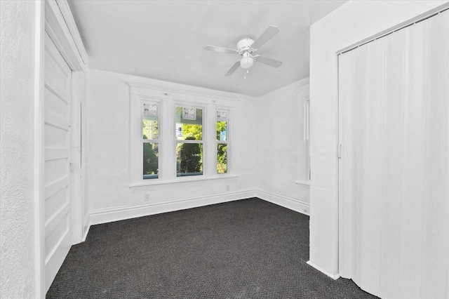 carpeted spare room with ceiling fan