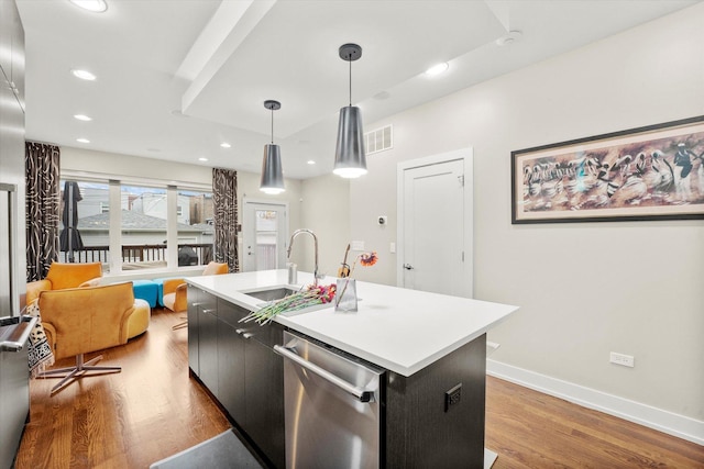 kitchen featuring dishwasher, sink, light hardwood / wood-style flooring, an island with sink, and decorative light fixtures