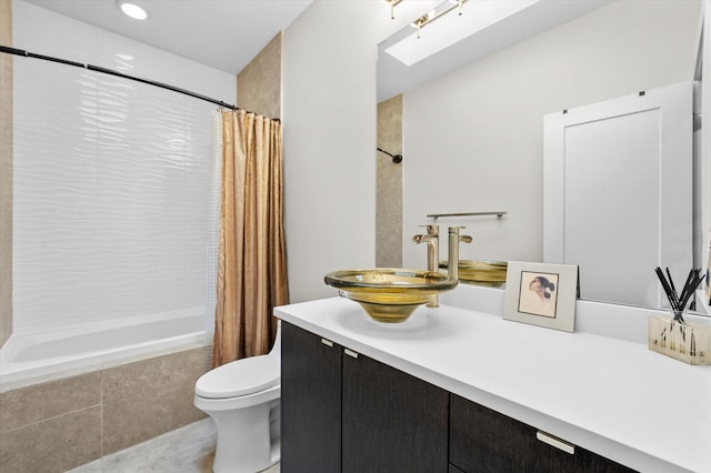 full bathroom featuring vanity, a skylight, toilet, and shower / bathtub combination with curtain