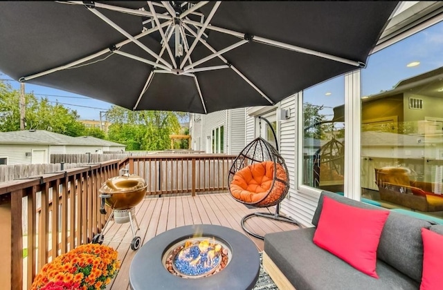 wooden deck featuring an outdoor fire pit