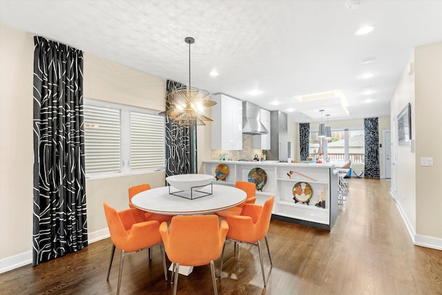 dining area featuring dark hardwood / wood-style floors and an inviting chandelier