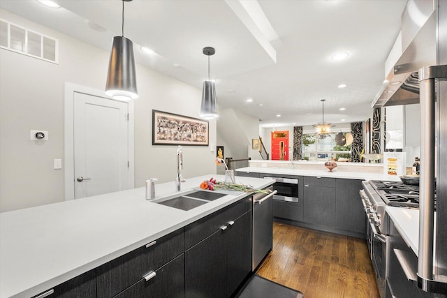 kitchen featuring kitchen peninsula, sink, dark wood-type flooring, and decorative light fixtures