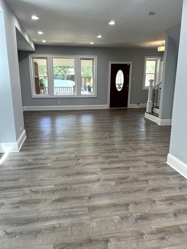 entrance foyer with dark wood-type flooring and a healthy amount of sunlight