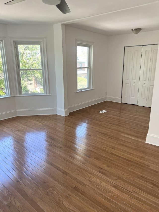 interior space featuring a closet, ceiling fan, and dark hardwood / wood-style flooring