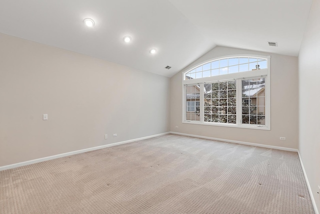 unfurnished room with lofted ceiling and light colored carpet