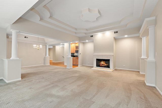 unfurnished living room featuring a raised ceiling, a chandelier, and light colored carpet