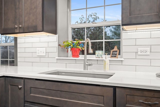 kitchen with tasteful backsplash, sink, and dark brown cabinets