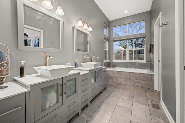 bathroom with vanity, tile patterned floors, and tiled bath